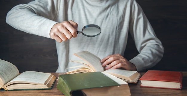 A person using a magnifying glass to examine a book review closely, symbolizing the need for careful scrutiny to detect bias and hidden agendas.