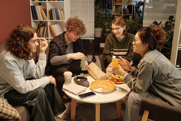 A group of book club members enjoying a themed potluck, with books visible on the table, showcasing social interaction and shared interests beyond just reading.