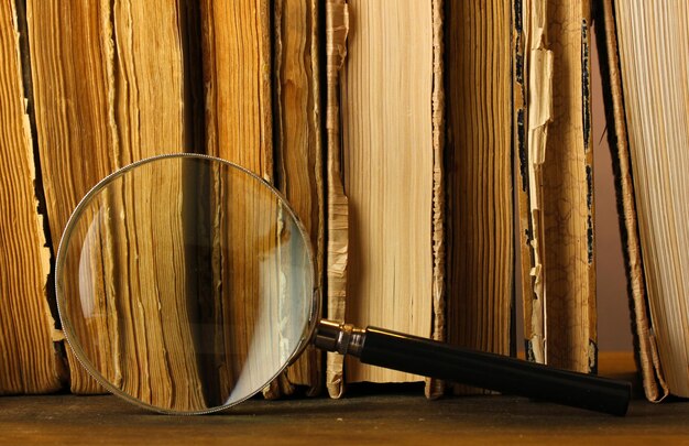 A magnifying glass hovering over a stack of neatly organized book manuscripts on a desk, symbolizing the careful selection process for agents and publishers.