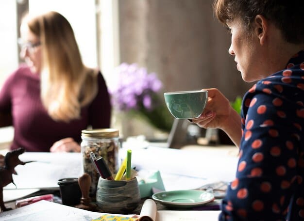 Two authors discussing creative ideas over coffee in a collaborative workspace, symbolizing partnership and shared literary passion.