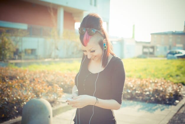 A person happily jogging outdoors with headphones on, listening intently to an audiobook on their smartphone, with a vibrant sunset in the background, symbolizing convenience.