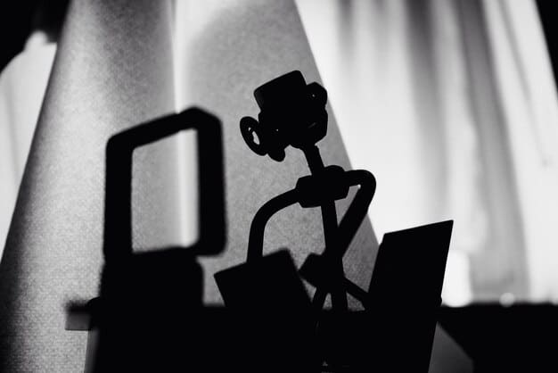 A silhouette of a screenwriter at a desk, surrounded by storyboards and film reels, symbolizing the creative process of adapting a book into a visual narrative.