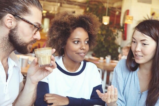 A diverse group of people engaged in conversation at a cafe, showing various expressions and interactions, symbolizing complex character relationships.