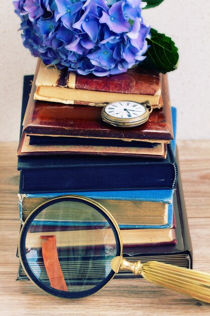 A stack of diverse books with various genres and themes, representing a carefully curated selection for a book club, with a magnifying glass hovering over the titles to suggest close examination.