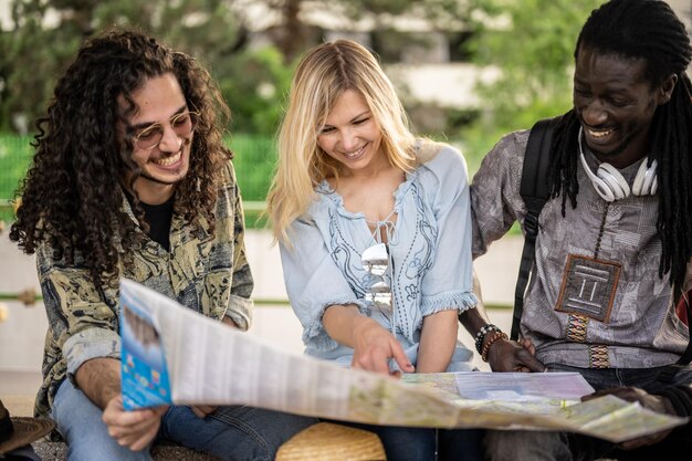 A group of friends laughing and pointing at a map of a literary festival, planning their next outing together.