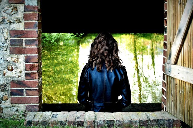 A person holding a remote control, with a split-screen reflection in a TV showing a book page on one side and a movie scene on the other, representing the dual experience of consuming a story.