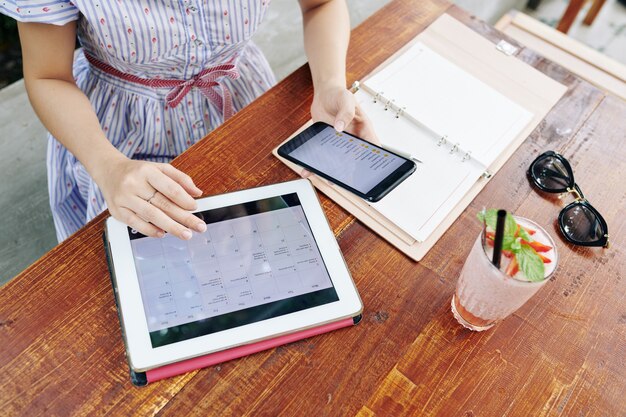A digital calendar application open on a tablet, showing multiple overlapping appointments, with a highlighted area indicating a potential free slot for a book club meeting. A pen rests beside the tablet.