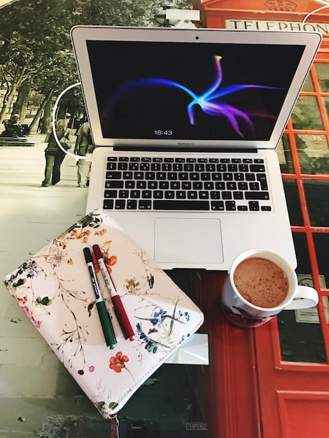A close-up shot of a laptop screen displaying a blog post with engaging fantasy artwork and clear, concise text, surrounded by notebooks and pens, suggesting a creative and analytical writing process.