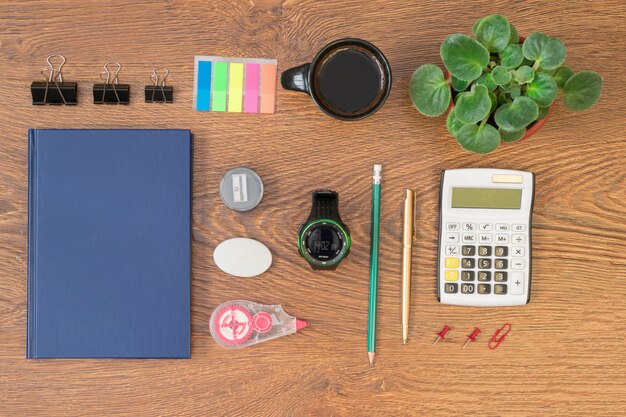 An overhead shot of a neatly organized desk with a calculator, a notebook with financial figures, a few coins, and an open planner, suggesting meticulous financial planning and organization for an author's marketing efforts.