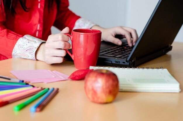 A writer actively typing on a laptop, surrounded by books and a coffee cup, suggesting a productive and dedicated work environment.