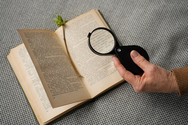 A close-up of a hand holding a magnifying glass over a passage in a book, with complex literary analysis notes scattered around, symbolizing in-depth intellectual scrutiny.