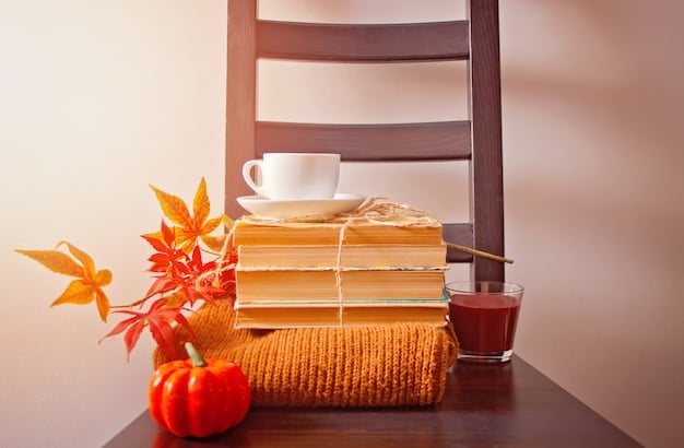 A stack of various books lying on a wooden table, with a cup of tea beside them. The lighting is soft and inviting.