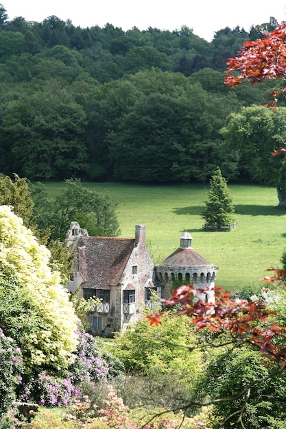A serene view of Dove Cottage in Grasmere, Lake District, England, surrounded by lush gardens. The cottage, once home to William Wordsworth, stands as a testament to literary history. The scene captures the tranquility and inspiration that the Lake District provides, in line with the concept of Literary Tourism: Visiting the Settings of Your Favorite Novels - A Review of Travel Guides.