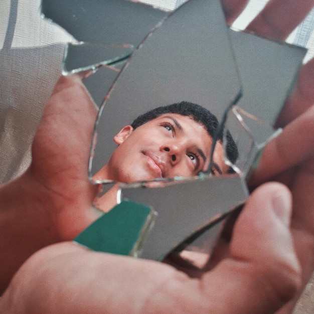 A close-up, slightly distorted reflection in a cracked mirror. The reflection shows a person with a haunted expression, surrounded by shadows. This image symbolizes the psychological torment and distorted reality often explored in Gothic Horror's Resurgence: Analyzing the Return of Atmospheric Dread and Psychological Torment.